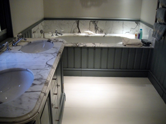 A luxurious bathroom with matching marble flooring and a centerpiece tub