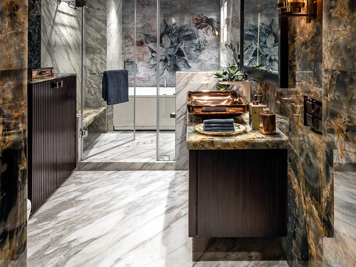 A bathroom with a wraparound marble design covering the floor, walls, and shower